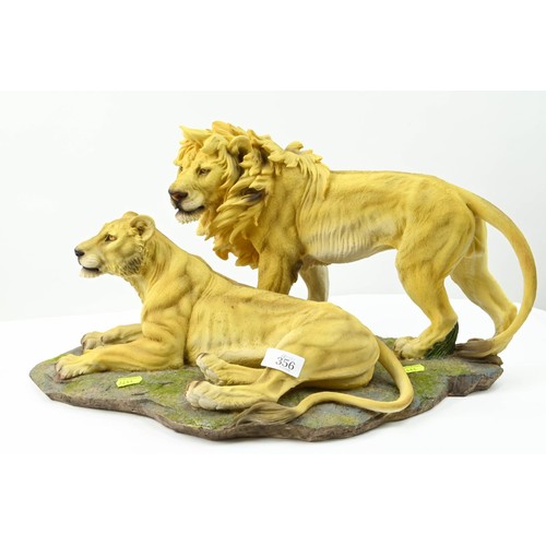 356 - Large resin sculpture of two lions. 52cm long x 26cm high.