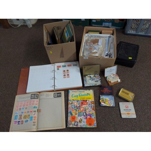 557 - Two boxes of mixed stamps, loose and albums of world stamps. 