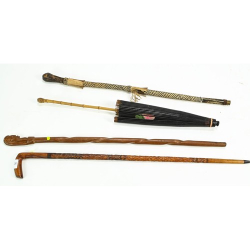 97 - Two carved walking sticks, one leather wrapped and an Asian parasol