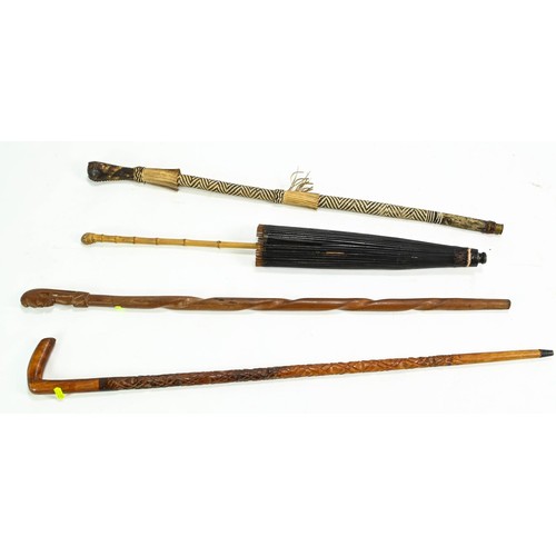 97 - Two carved walking sticks, one leather wrapped and an Asian parasol