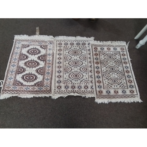 127 - Three small rugs with similar Aztec design and all with frills. 100 x 61 cm