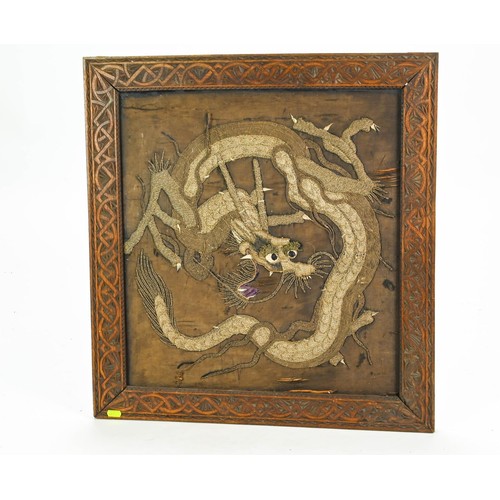 76 - Asian gilt thread embroidery of a dragon in carved oak frame 67 x 63cm
