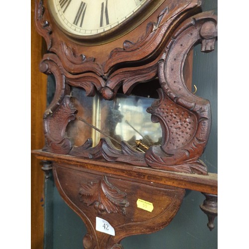 42 - Oak decoratively carved wall clock marked 'F. Needham' to dial, with pendulum, ht.76cm face dia. 31c... 