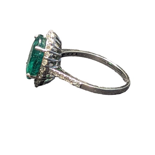 87 - Emerald and diamond halo cluster ring with diamond set shoulders, mounted on 18ct white gold. The cl... 