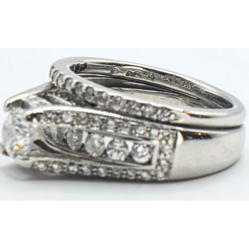 86 - 14ct white gold and diamond ring. Comprising of two rings soldered together. Central round brilliant... 