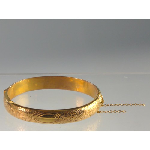 150 - 15ct gold hinged bracelet, engraved with flowers and scrolls to one side, hallmarked Birmingham 1918... 