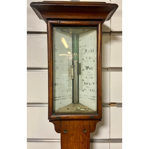 446 - Edwardian stick barometer in oak casement showing Fahrenheit and Centigrade.L99 cm