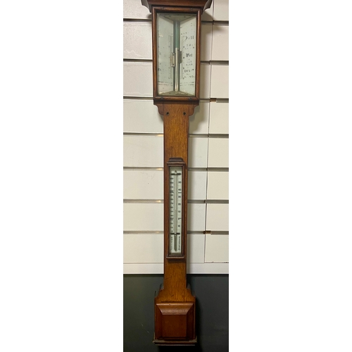 446 - Edwardian stick barometer in oak casement showing Fahrenheit and Centigrade.L99 cm