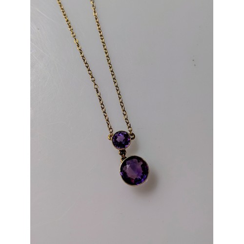 167 - 9ct gold and amethyst pendant on a 9ct gold chain. The two amethysts are modified brilliant cut in a... 