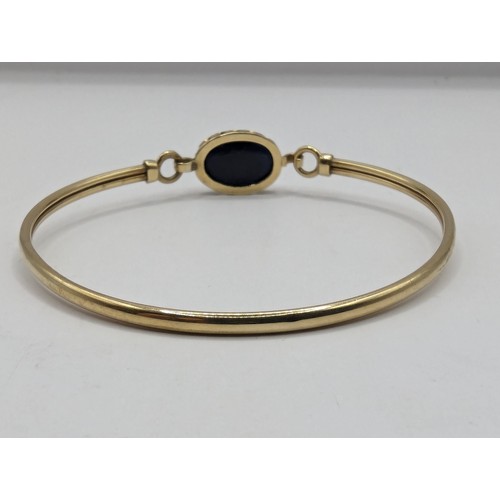 227 - 9ct gold bangle set with cabochon paste stone, gross weight 5.5g