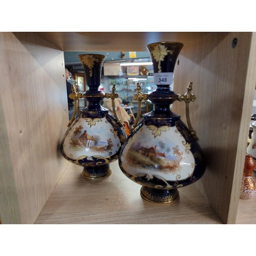 348 - Pair of English cobalt blue ground vases, each with a painted cottage scene, height 30.5cm. See cond... 