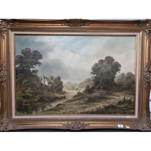 33 - Arthur Read - Oil on canvas of a landscape with cottage in a gilt frame. 112cm x 82cm.