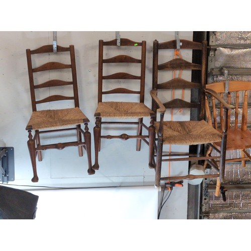 490 - Three ladder backed rush seated chairs, inc. one carver