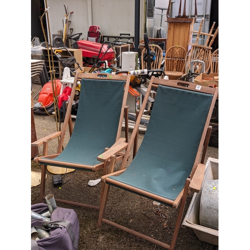 118 - Pair of teak framed deckchairs with green fabric seats