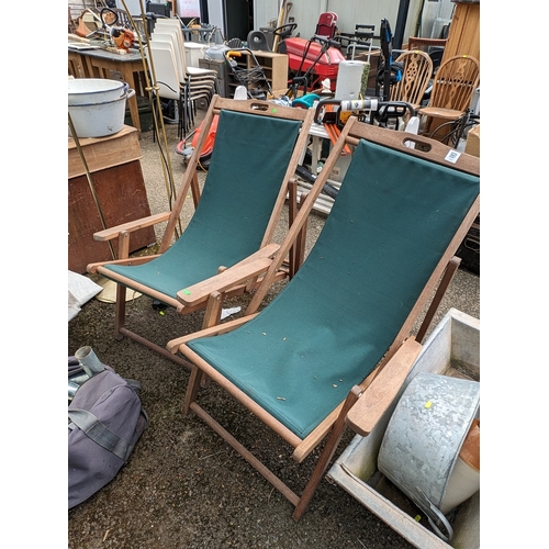 118 - Pair of teak framed deckchairs with green fabric seats