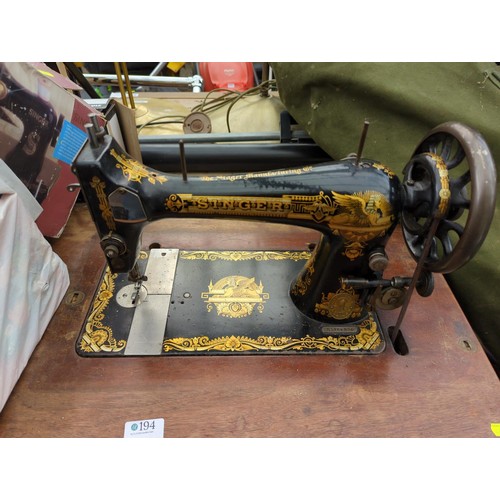 194 - Singer sewing machine on treadle base with some accessories