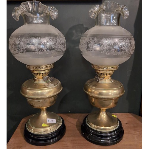 174 - Pair of decorative brass oil lamps with decorative clear glass shades, no flues present