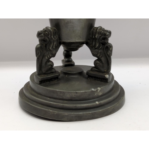 225 - Pewter trumpet shaped vase supported by three lions, height 28cm