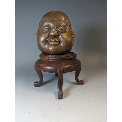 467 - Four sided Buddha head, character marks to the base brass, on a wooden stand. total height 22cm appr... 