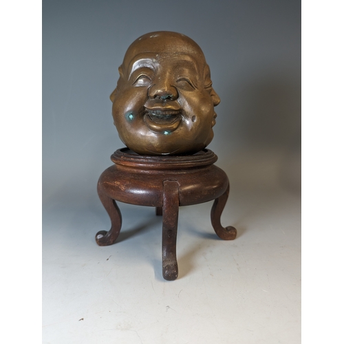 467 - Four sided Buddha head, character marks to the base brass, on a wooden stand. total height 22cm appr... 