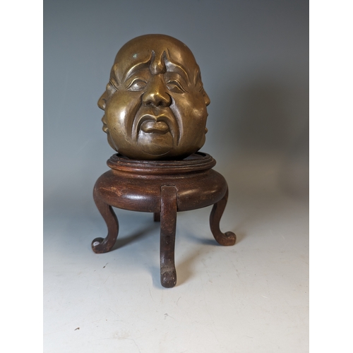 467 - Four sided Buddha head, character marks to the base brass, on a wooden stand. total height 22cm appr... 