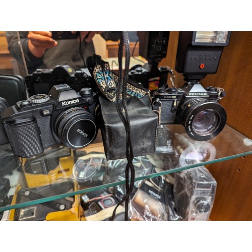 730 - Three shelves of cameras and accessories inc. Rollei 35 LED, Rollei A110, Konica, Pentax, Samsung et... 