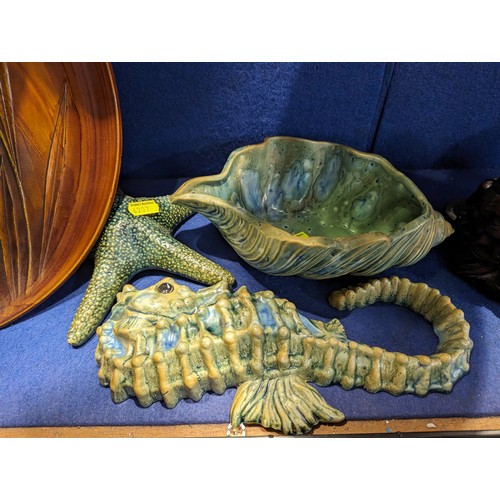 736 - Two studio pottery sealife decorations, daffodil relief tray and a resin sow with piglets