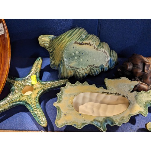 736 - Two studio pottery sealife decorations, daffodil relief tray and a resin sow with piglets