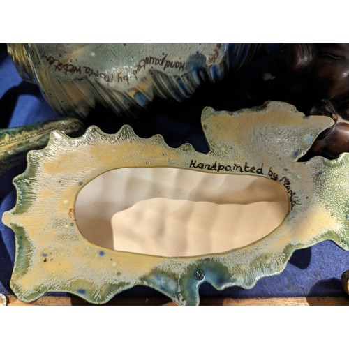 736 - Two studio pottery sealife decorations, daffodil relief tray and a resin sow with piglets