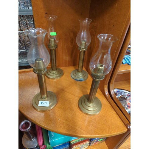 777 - 4 x brass candle sticks with glass shades + a quantity of different size candles  