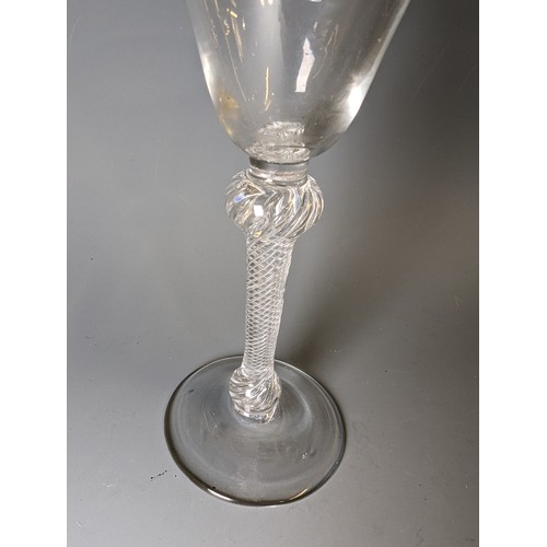 232 - Double-knopped air twist wine glass, circa 1750, the round funnel bowl above a multi-spiral stem and... 