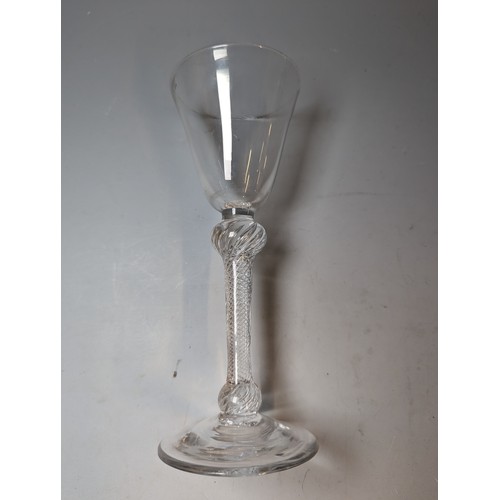 232 - Double-knopped air twist wine glass, circa 1750, the round funnel bowl above a multi-spiral stem and... 