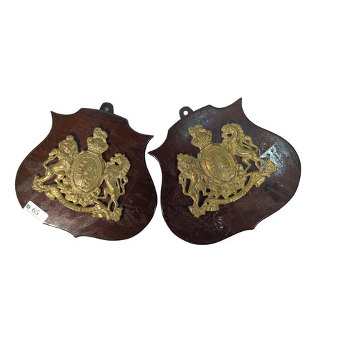65 - Pair of brass British Royal Coat of Arms crests on wooden shields.
