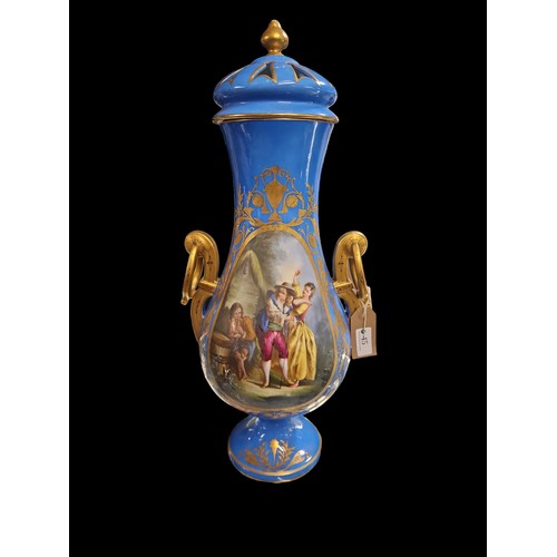 45 - Large lidded vase with figural scene to front and flowers to back. Gilt handles and highlights. H55c... 