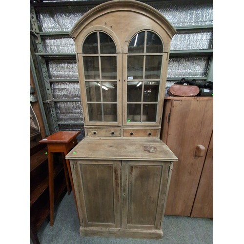 852 - Small, stripped pine, arch-topped, glazed dresser with 2 small drawers over cupboard. W82cm, D52cm, ... 