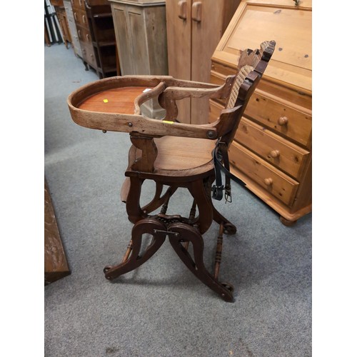 857 - Antique, metamorphic, wheeled highchair/rocker with cane backrest.