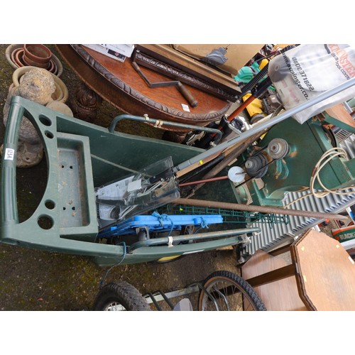 123A - Green plastic barrow with contents inc new loppers,long handled tools, blue trolley, shooting stick ... 