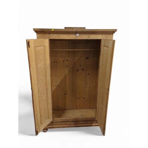 640 - Strip pine, double door wardrobe. With relief emblems to both doors. On bun feet. W120cm, D57cm, H18... 