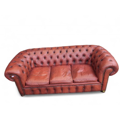 702 - Red leather Chesterfield style 3 seat settee. W211cm D96cm H76cm