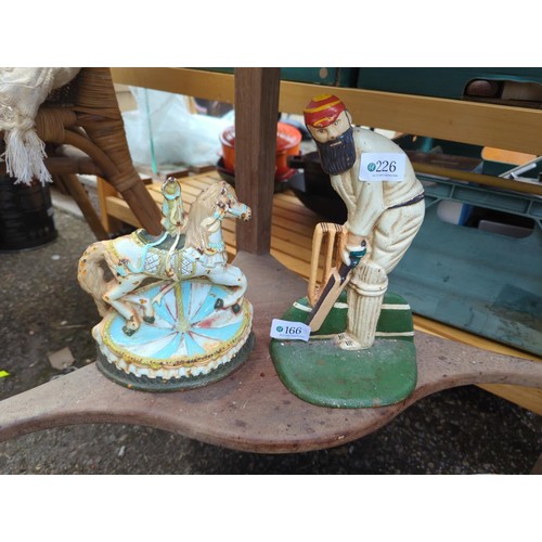 166 - 2 cast iron doorstops, WG Grace (24cms ht) & a carousel horse,