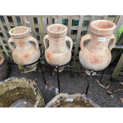 33 - 3 Greek style amphorae jar garden ornaments in metal stands. H59cm (in stand)