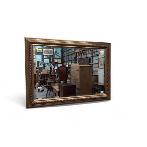 581 - Gilt framed bevelled mirror. W108cm H77cm