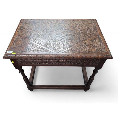 577 - A heavily carved oak occasional table, with box stretched turned supports. W78cm D52cm H71cm