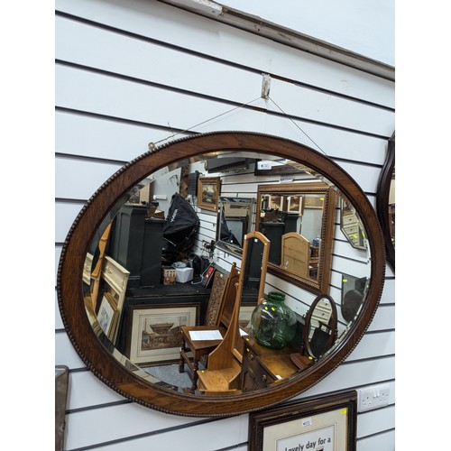 745 - Large oval oak framed mirror. W100cm h80cm