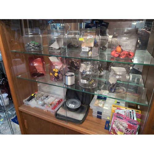 823 - Fishing weights, hooks and lures in cabinet over three shelves