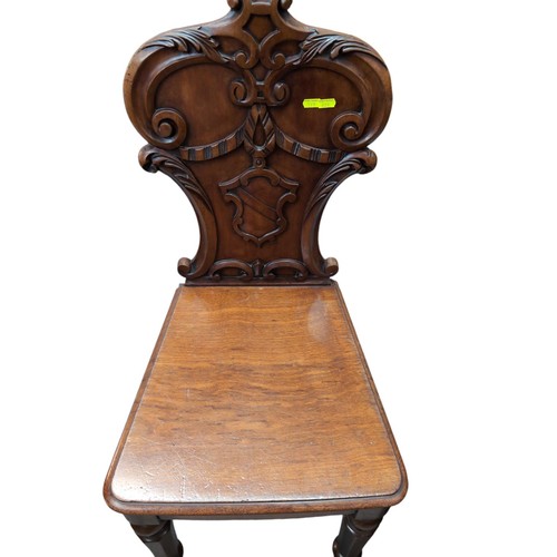 107 - Pair of carved mahogany hall chairs.