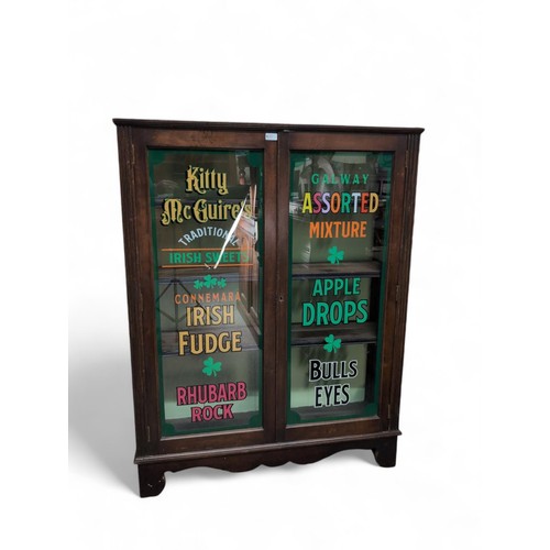 97 - Early C20 glazed cabinet, with later signwriting for Kitty McGuire's Traditional Irish Sweets. W103c... 