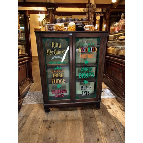 97 - Early C20 glazed cabinet, with later signwriting for Kitty McGuire's Traditional Irish Sweets. W103c... 