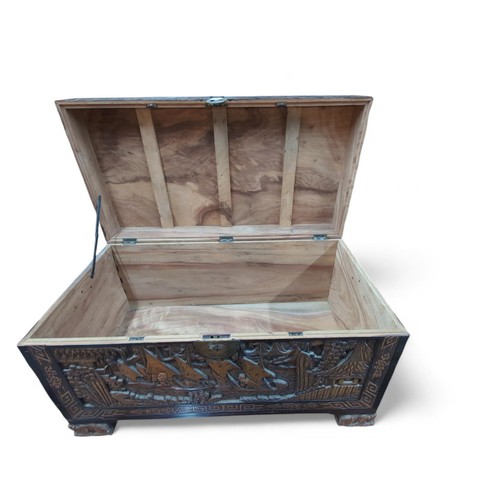 122 - Camphor wood carved Asian chest depicting junks and landscapes. W106.5cm D55cm H60cm. Raised on Fo d... 