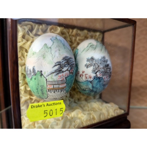 322 - Glass cased hand painted eggs